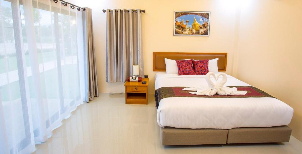 a bedroom with a bed with a white angel on it at Lampang Green Garden Resort in Ban Chomphu