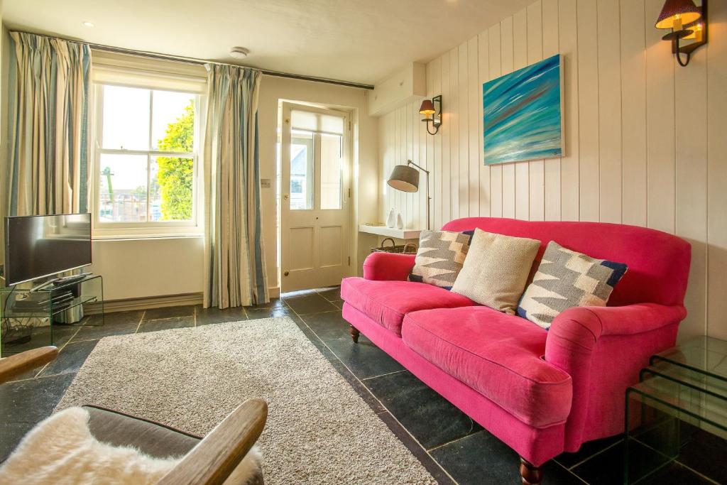 - un salon avec un canapé rouge et une télévision dans l'établissement Nutshell, à Aldeburgh
