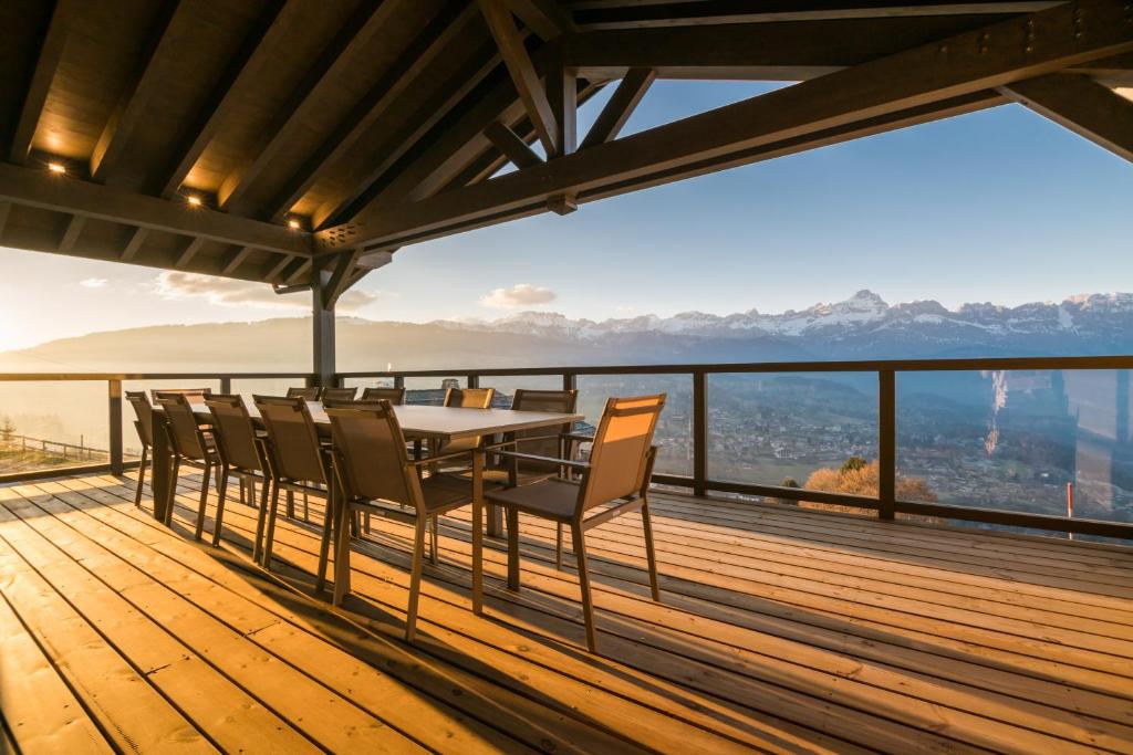a table and chairs on the deck of a house with a view at Chalet Intages in Combloux