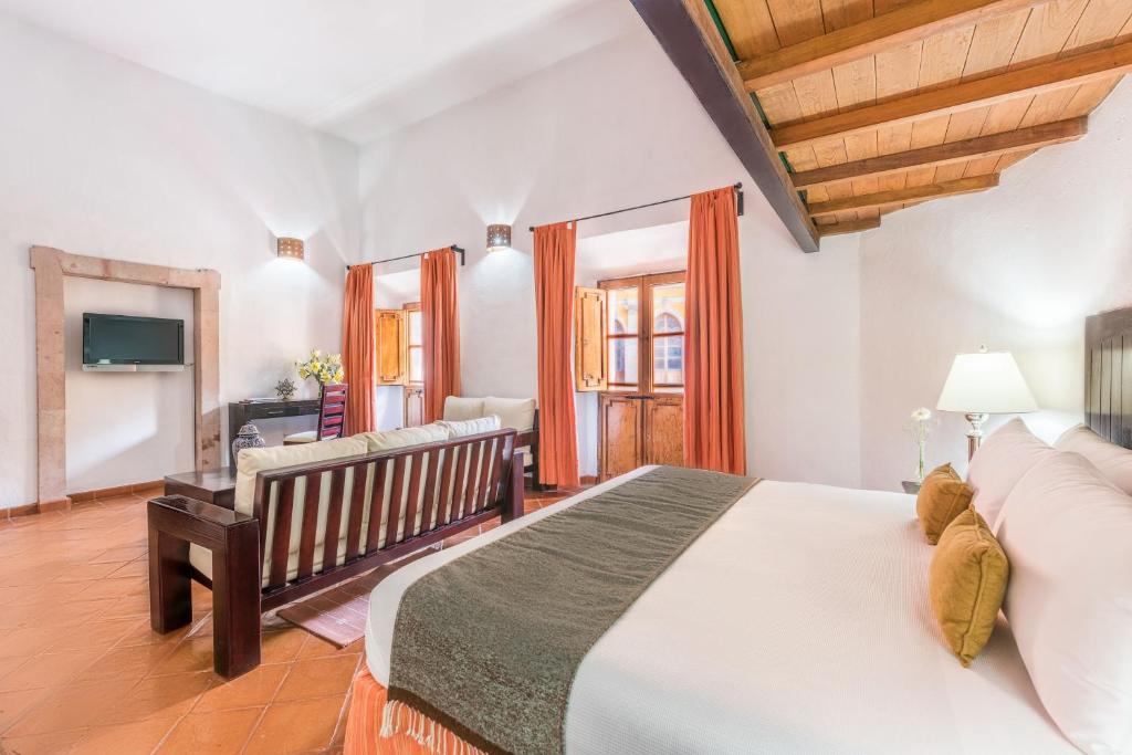 グアナファトにあるオテル カサ ヴィレイエスのベッドルーム(大きな白いベッド1台、ベビーベッド1台付)