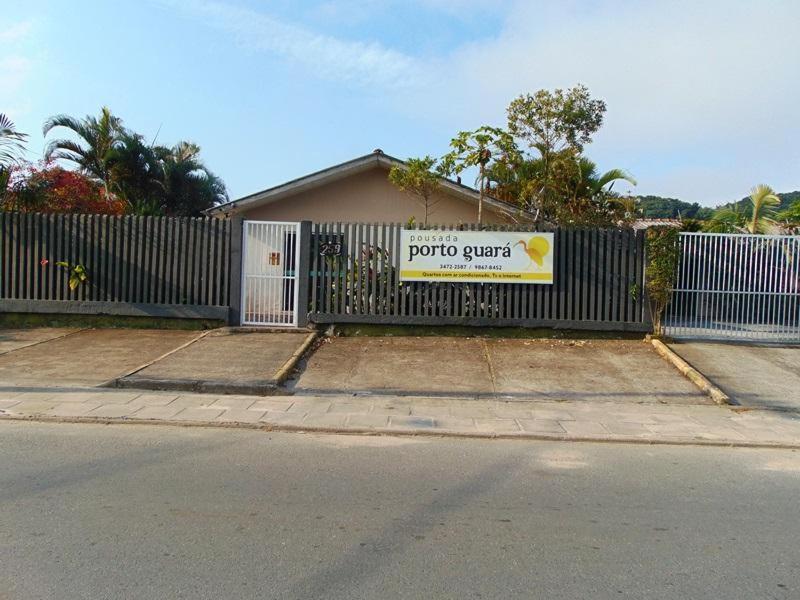 einen Zaun mit einem Schild an der Seite eines Hauses in der Unterkunft Pousada Porto Guará in Guaratuba