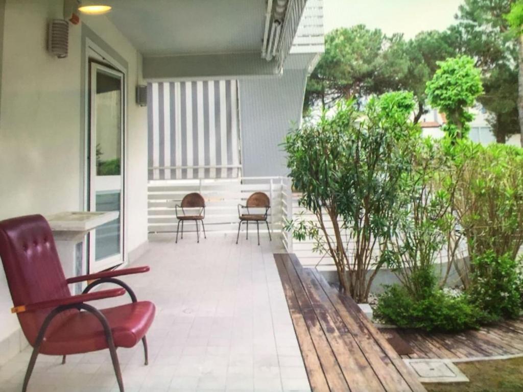 une terrasse avec des chaises et des tables dans une maison dans l'établissement Casa con giardino, à Cervia