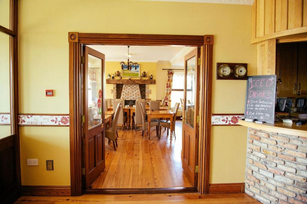 a kitchen and dining room with a dining table and a door at Pier House Bed & Breakfast in Inis Mor