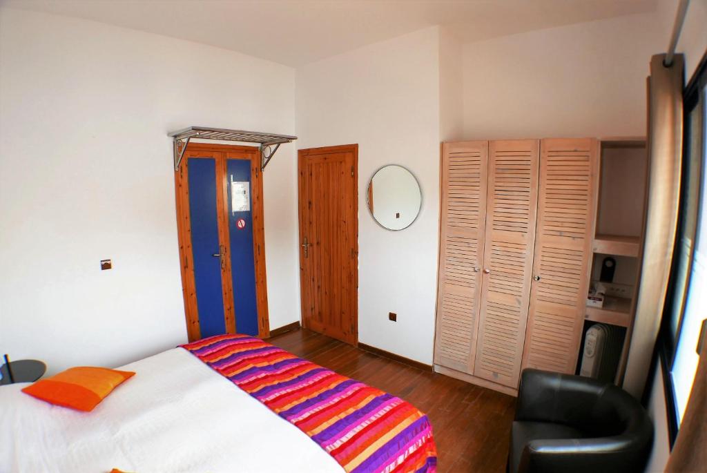 a bedroom with a bed and a chair in it at logis la marine in Sidi Ifni