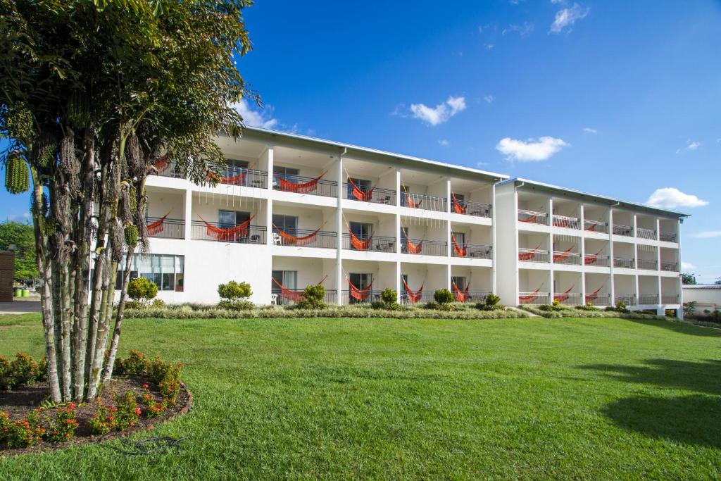 een groot wit gebouw met rode stoelen op de balkons bij Hotel Montserrat Plaza in Monterrey