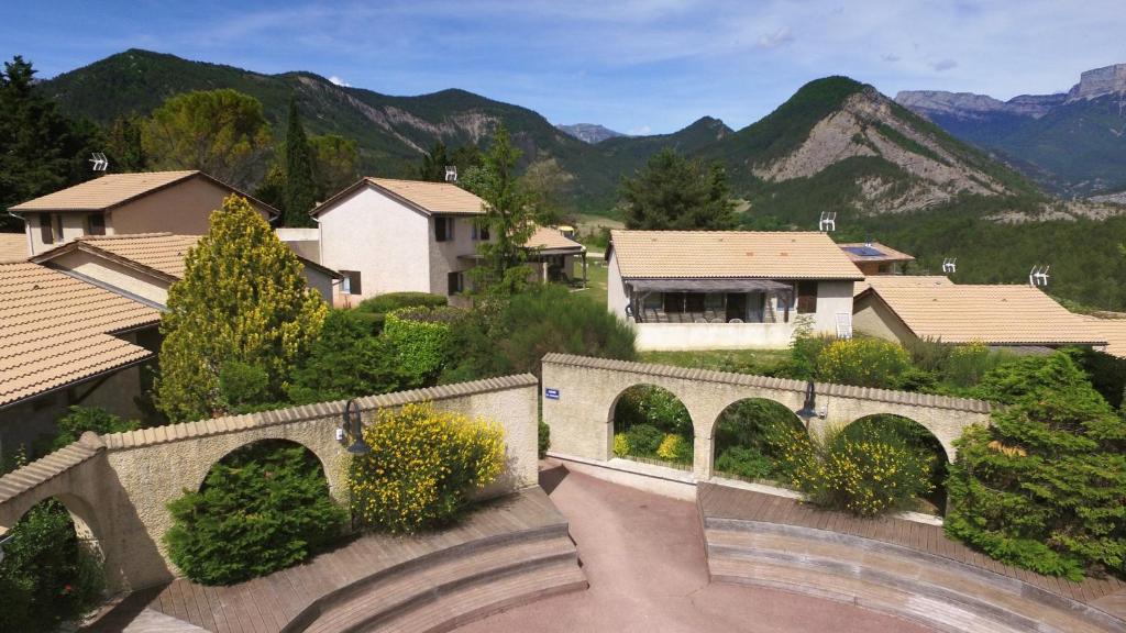 an aerial view of a town with a bridge and mountains at VVF Sud Vercors in Die