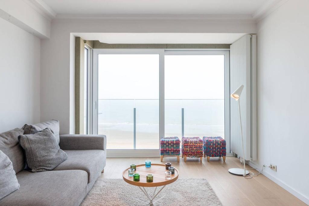 a living room with a couch and a table at Sea View Apartment Knokke in Knokke-Heist