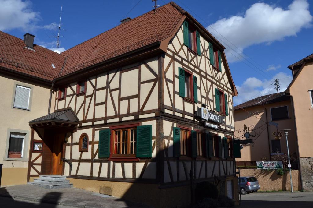um edifício com persianas verdes e brancas em Pension Krone Sternenfels em Sternenfels