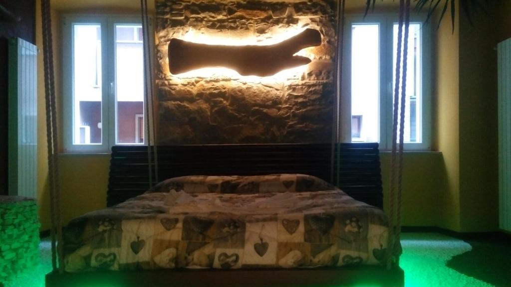 a bed in a room with a stone fireplace at Thematic Rooms - AThema Atmosphere in Trieste