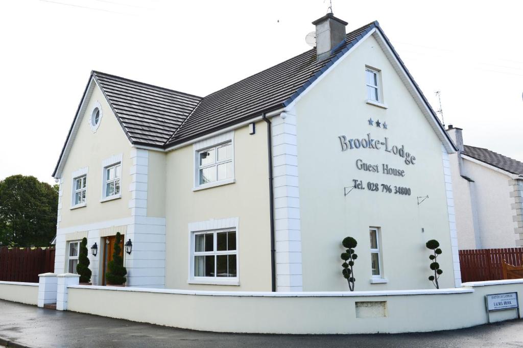 un edificio blanco con escritura a un lado. en Brooke Lodge Guesthouse, en Magherafelt