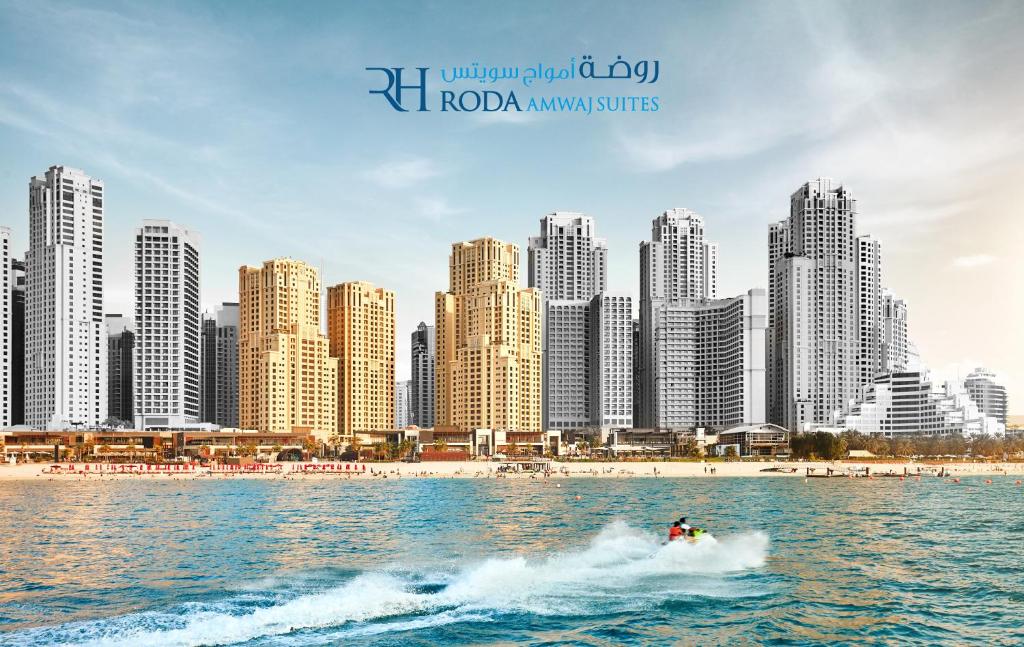 ein Boot im Wasser vor einer Stadt in der Unterkunft Roda Amwaj Suites Jumeirah Beach Residence in Dubai