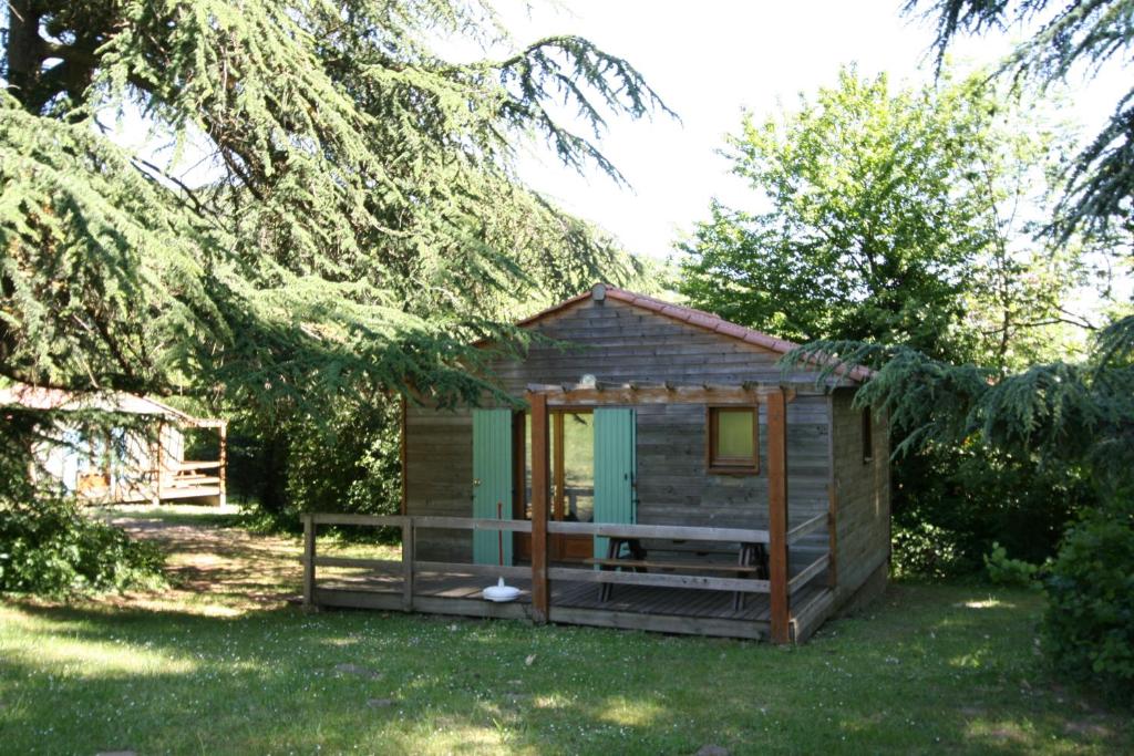 une petite cabine avec une terrasse couverte dans la pelouse dans l'établissement Les Chalets du Domaine des Soyeux, à Saint-Julien-Molin-Molette