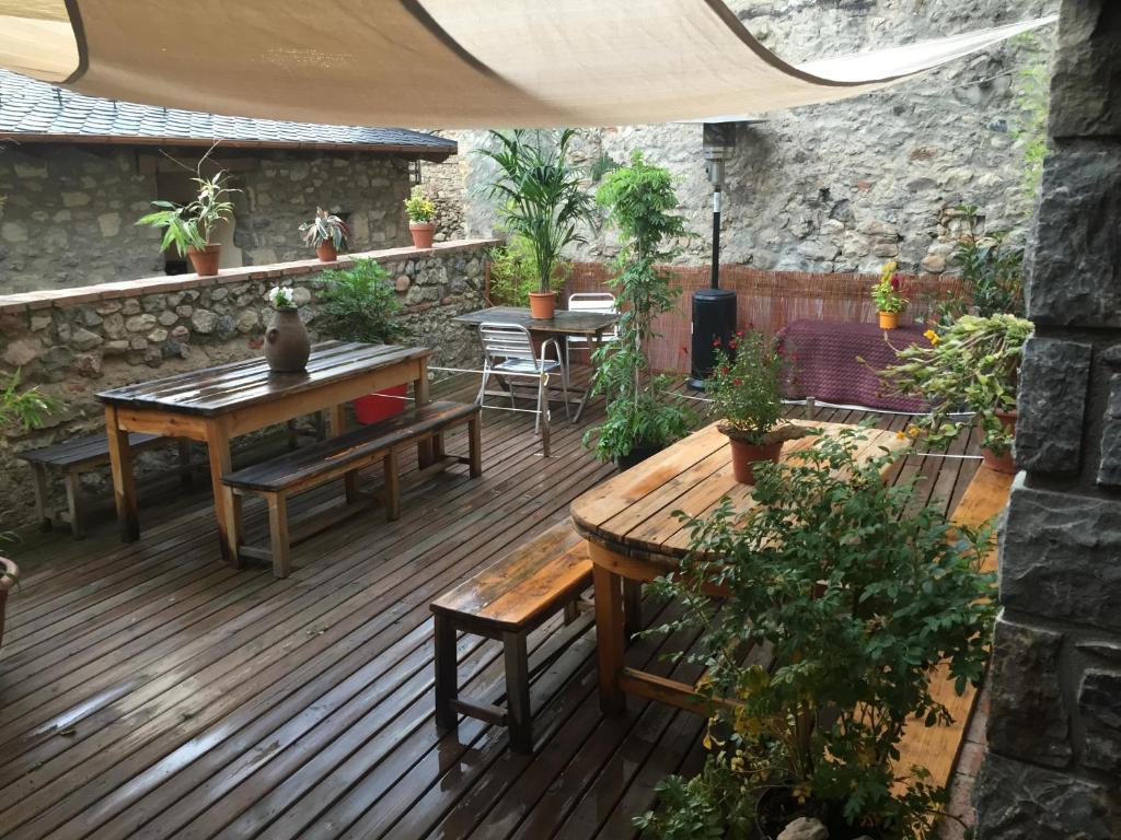 un patio con mesas y bancos en una terraza de madera en La Calma de Bellver, en Bellver de Cerdanya 