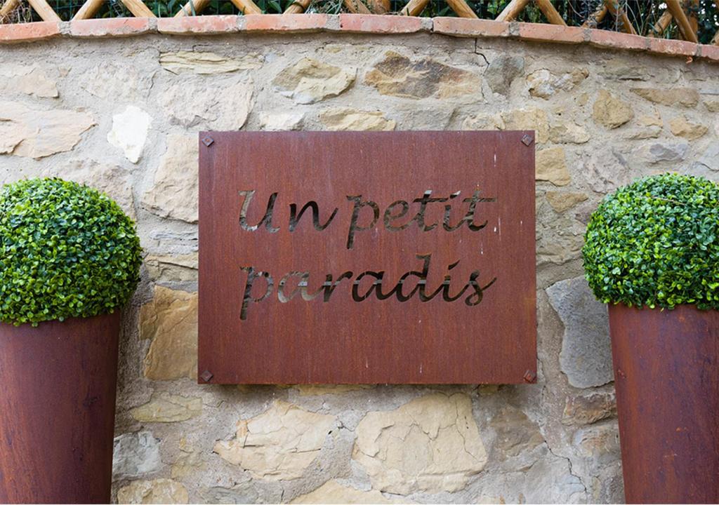 un cartel en una pared de piedra con dos plantas en Un Petit Paradis, en Castiglione della Valle