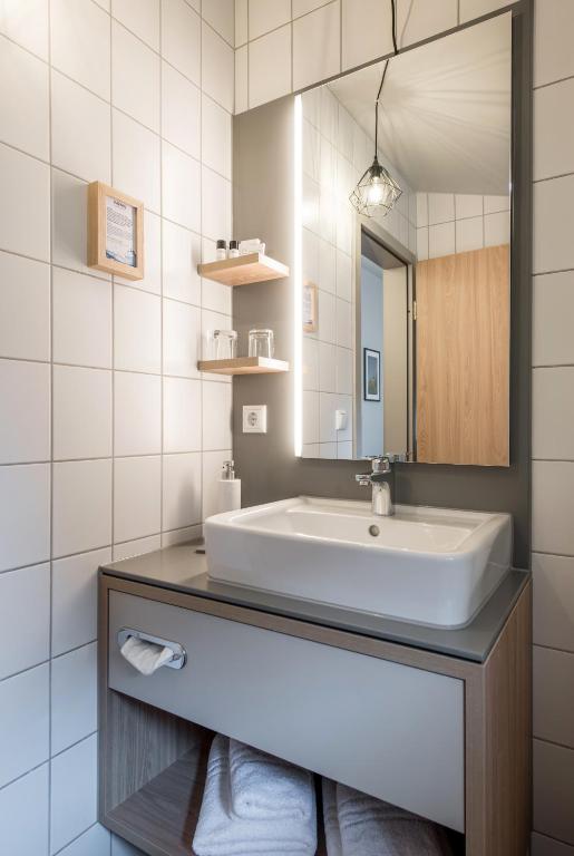 łazienka z umywalką i lustrem w obiekcie stattHotel Weimar w mieście Weimar