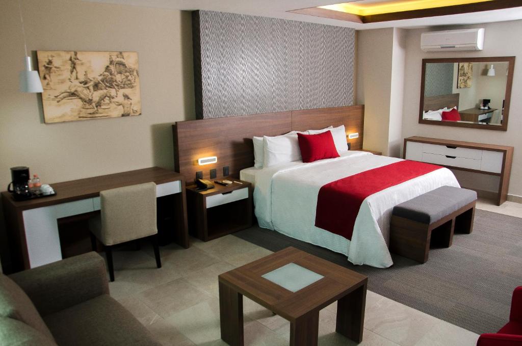 a hotel room with a large bed and a desk at Hotel 5 de Mayo in Puebla