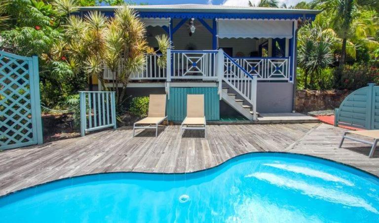 a house with a swimming pool in front of a house at Habitation Capado in Deshaies