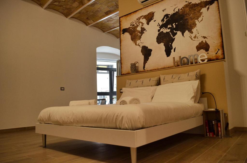 a bedroom with a large bed with a world map on the wall at B&B Chiostro San Marco in Tarquinia