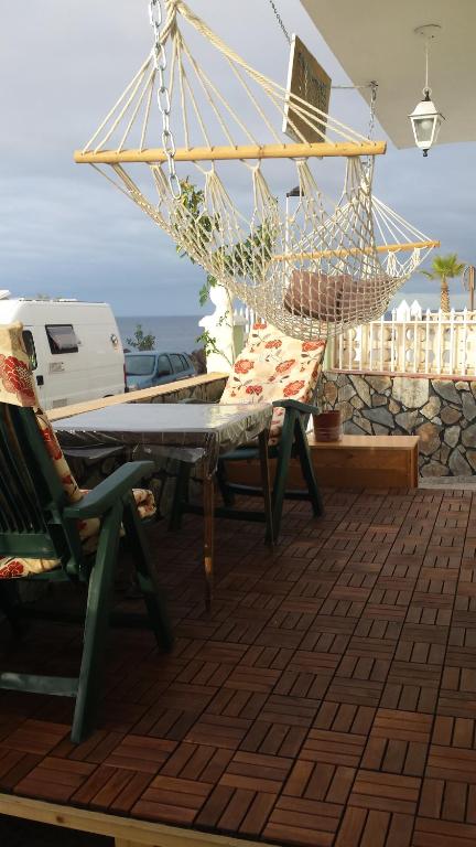 サンタクルス・デ・テネリフェにあるHouse Tenerife Southのハンモック、テーブル、椅子付きのパティオ