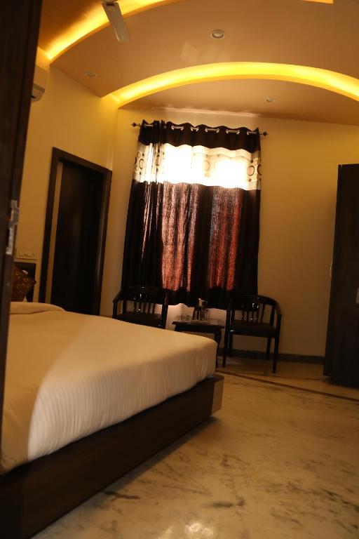 Habitación de hotel con cama y ventana en Hotel Delight, en Udaipur