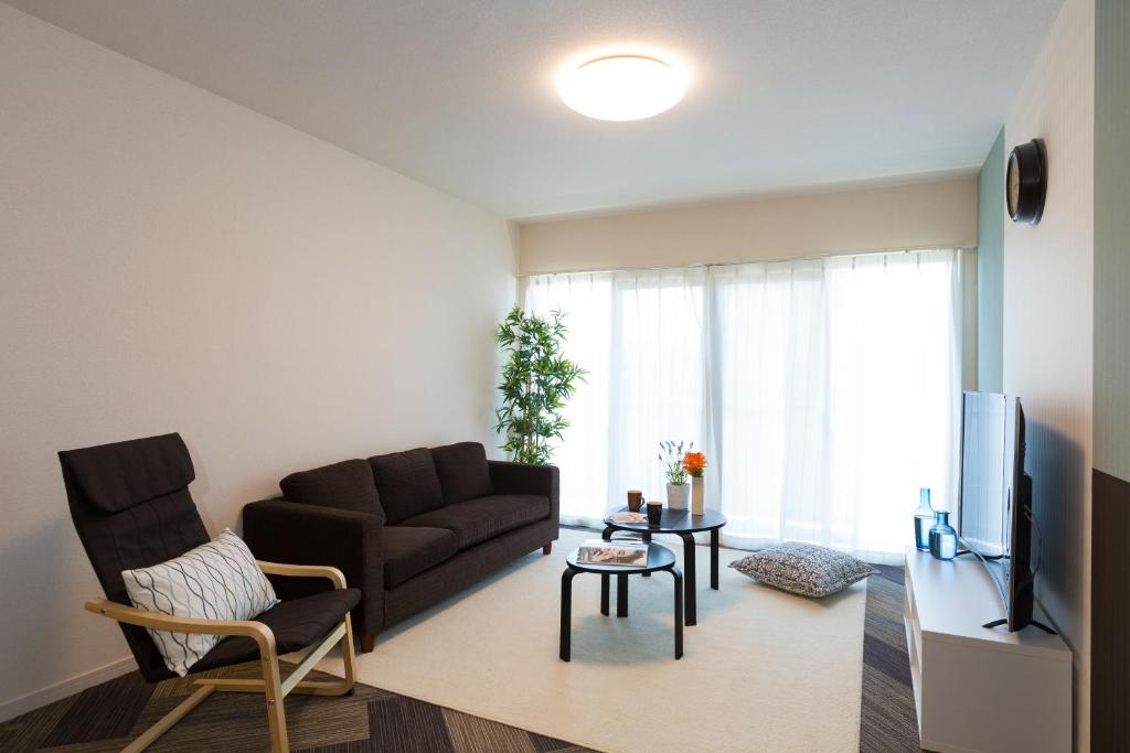 a living room with a couch and a tv at The Metropolitan in Fukuoka