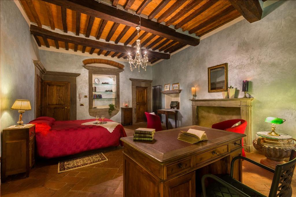 カスティリオーン・フィオレンティーノにあるSuite La Giocondaのベッドルーム(赤いベッド1台、テーブル付)