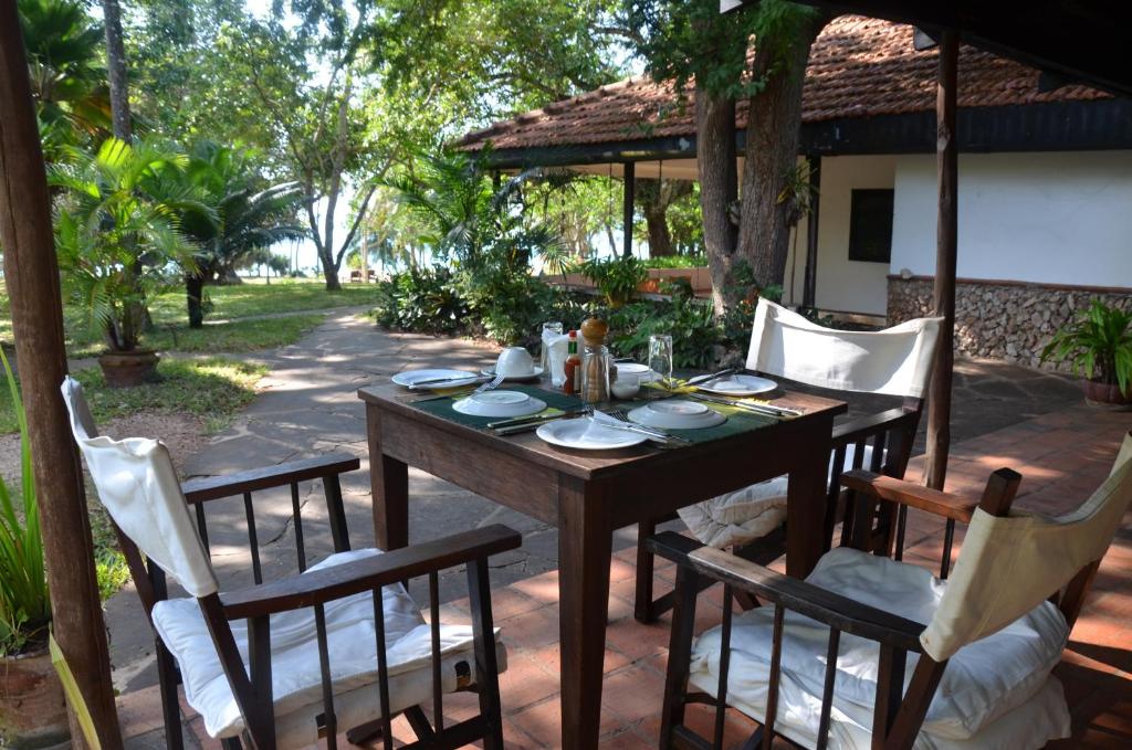 a wooden table and chairs on a patio at Diani House in Diani Beach