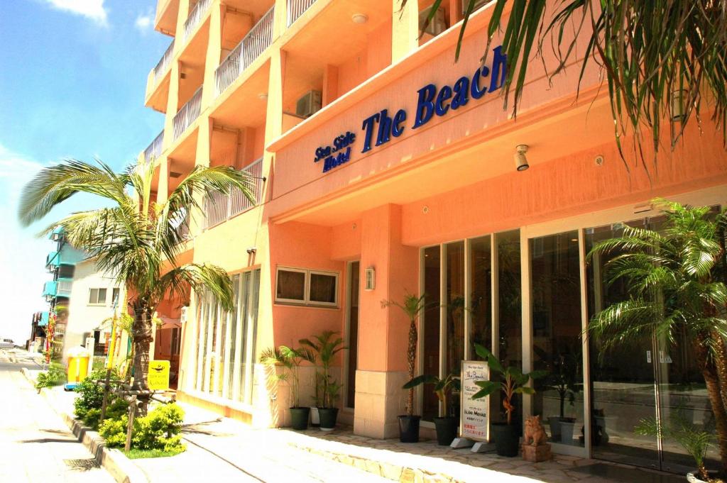 un edificio con un cartel que lee se encuentra con la playa en Seaside Hotel The Beach en Chatan