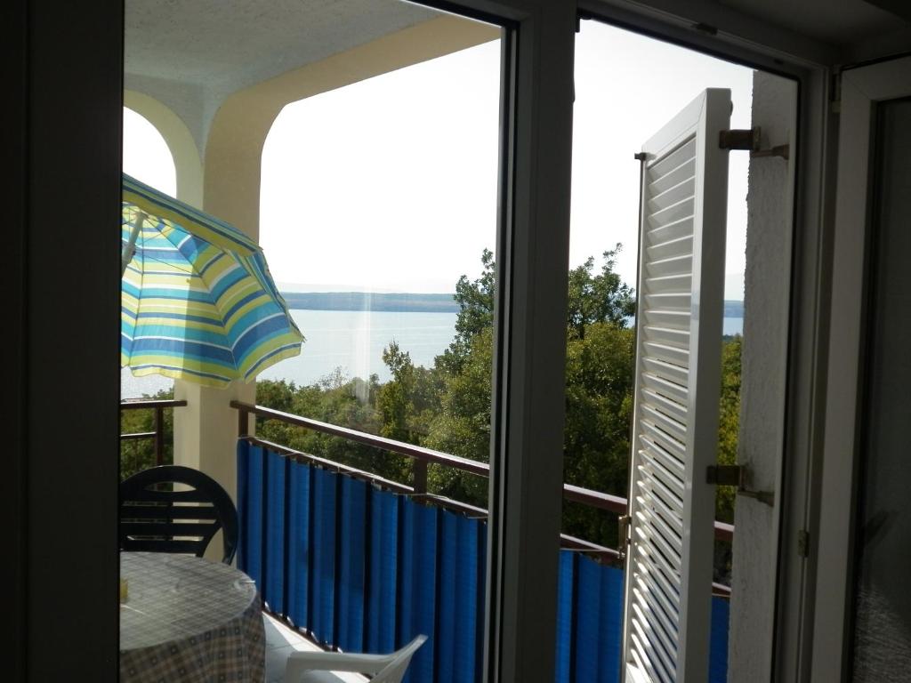 a balcony with a view of the ocean through a window at Apartment Antoncic in Dramalj