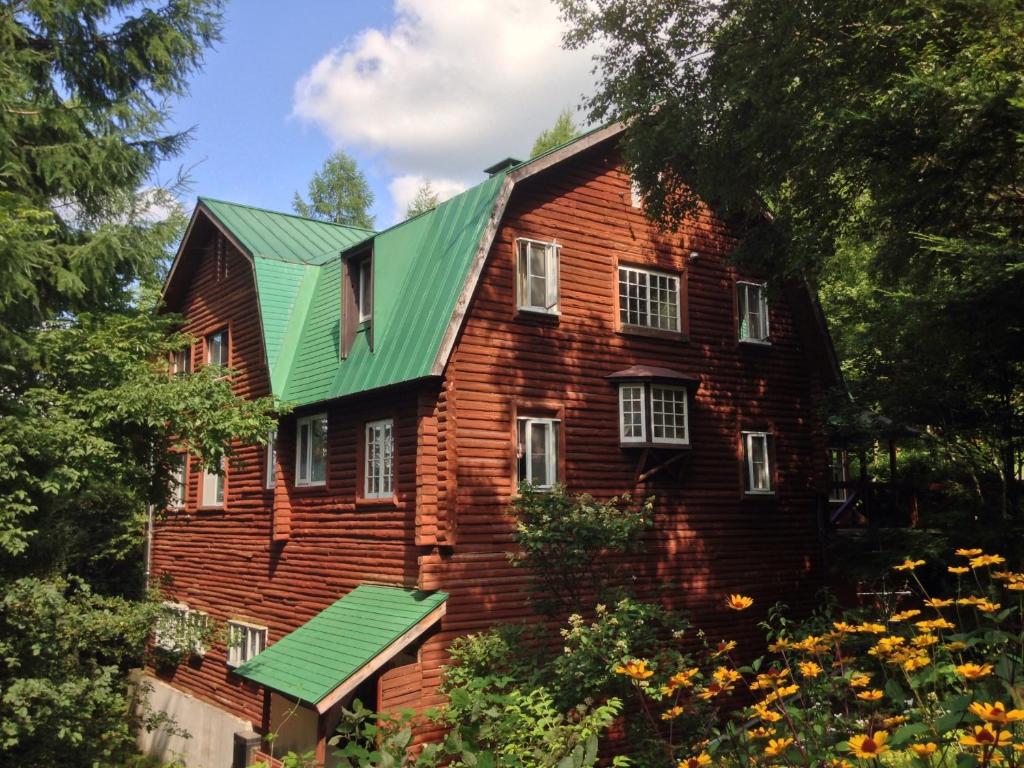 stary dom z czerwonej cegły z zielonym dachem w obiekcie Resort Garni CORU w mieście Nagawa