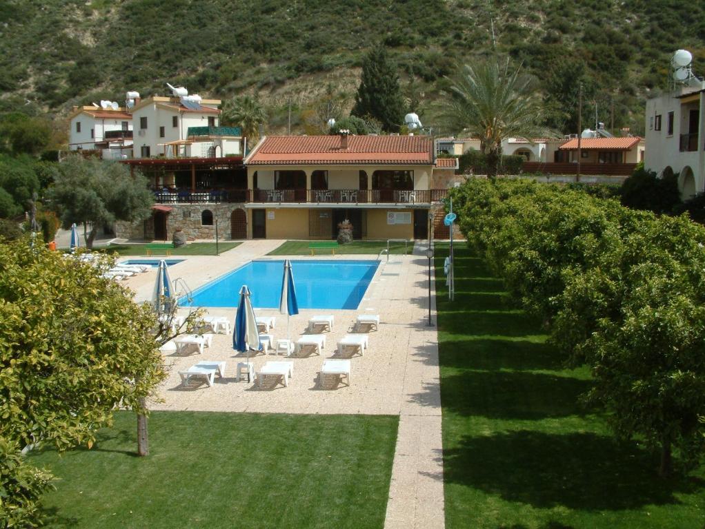 a resort with a swimming pool and a house at Pelekanos Apartments in Pissouri