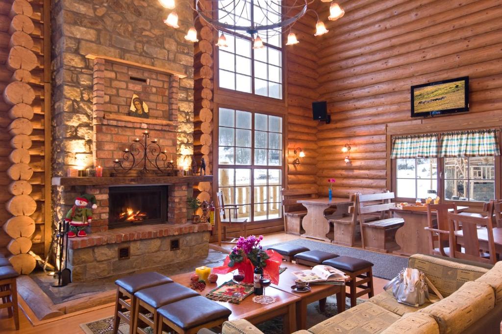 a living room with a fireplace in a log cabin at Sfendamos Wood Village in Agios Pavlos