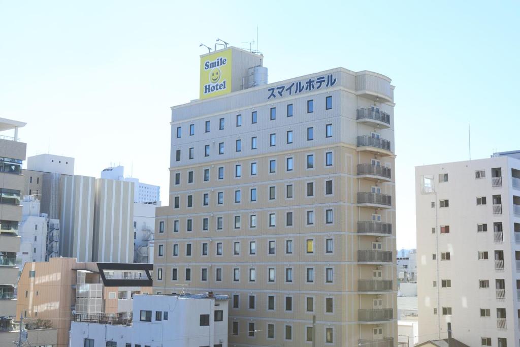 a tall building with a sign on top of it at Smile Hotel Shizuoka in Shizuoka