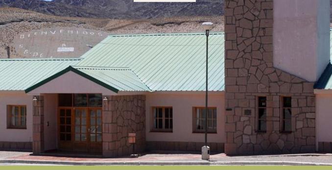 ein Gebäude mit einem grünen Dach und einer Straßenbeleuchtung in der Unterkunft Hotel de Las Nubes in San Antonio de los Cobres