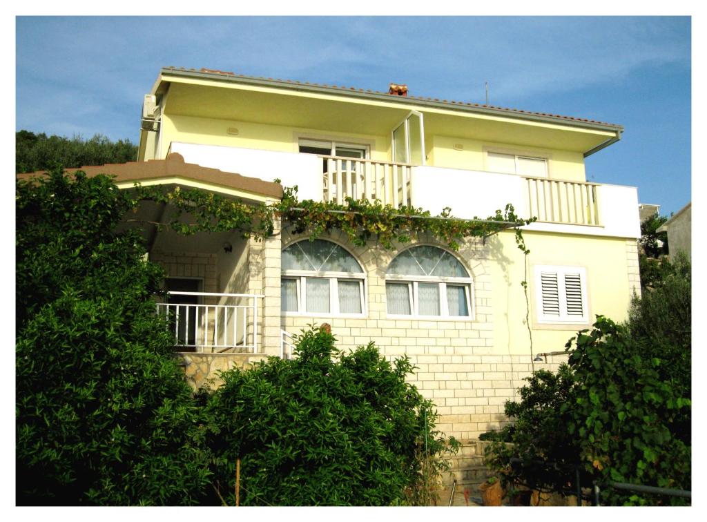 Una casa amarilla con balcón en la parte superior. en Blue Sensation, en Okrug Donji