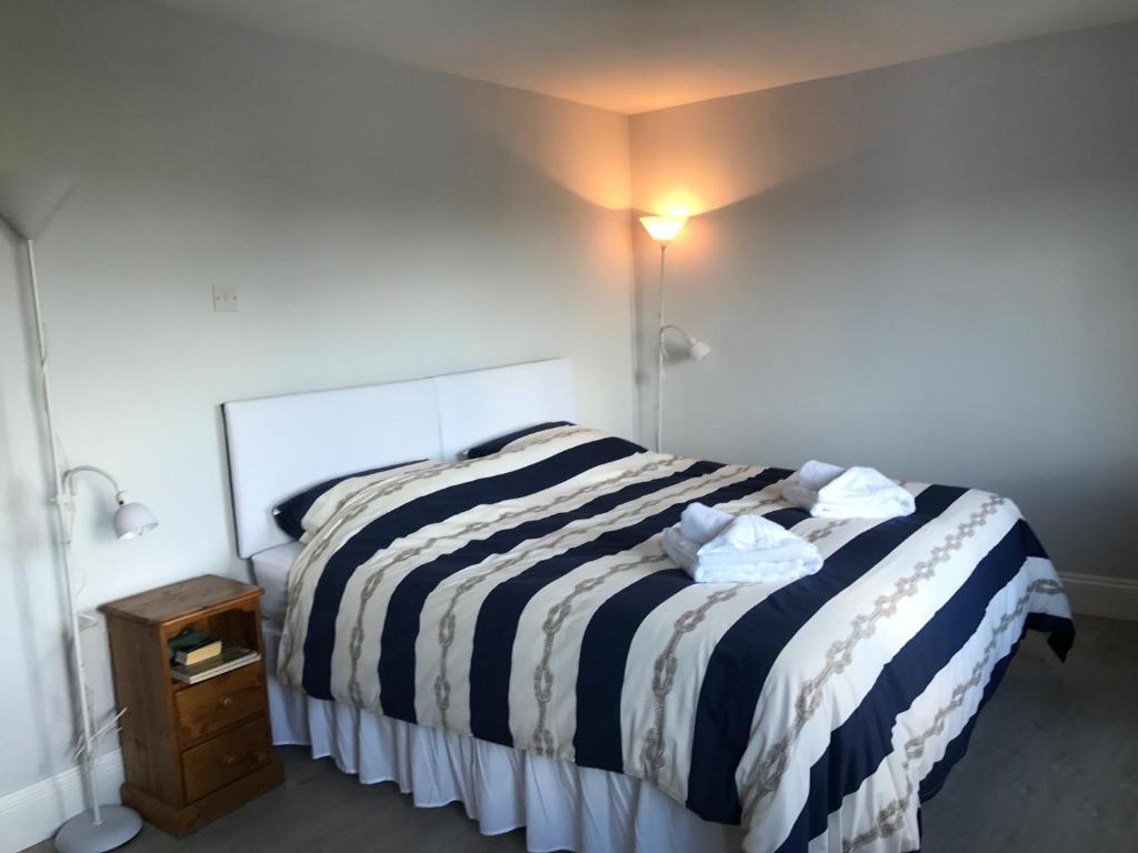 a bed with a black and white striped comforter in a room at The Red Lion Inn in Dittisham