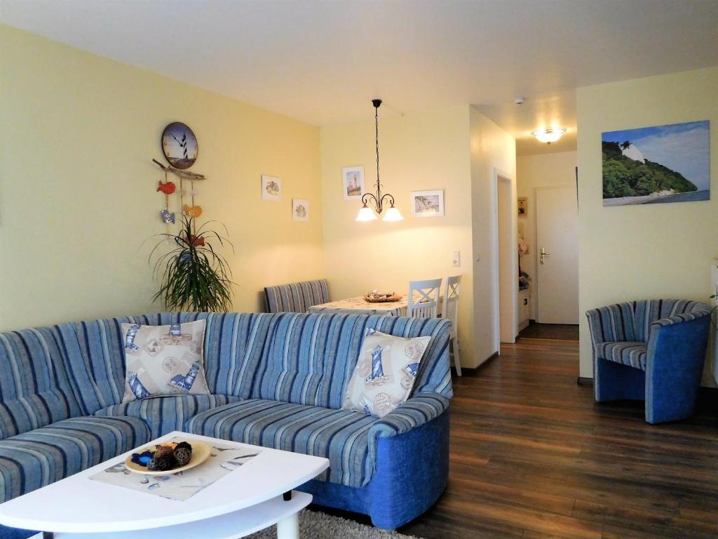 a living room with a blue couch and a table at Ferienwohnung Leuchtturm in Sassnitz