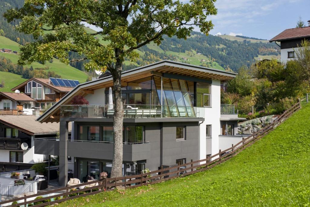 una casa en una colina con un árbol en Bellaire Tirol, en Westendorf