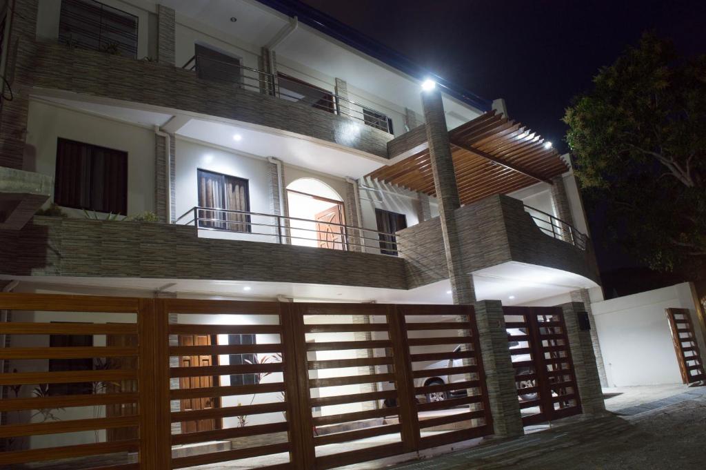 une maison avec une clôture en bois devant elle dans l'établissement Abeth's Haven, à Puerto Princesa