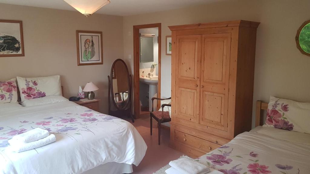 a bedroom with two beds and a bathroom with a mirror at Hosefield Bed and Breakfast in Ellon