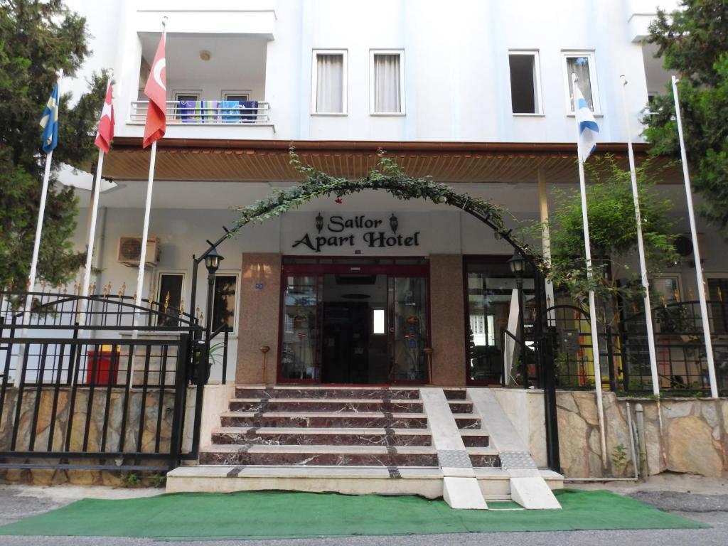 un edificio con una entrada con banderas delante en Sailor Apart Hotel, en Alanya