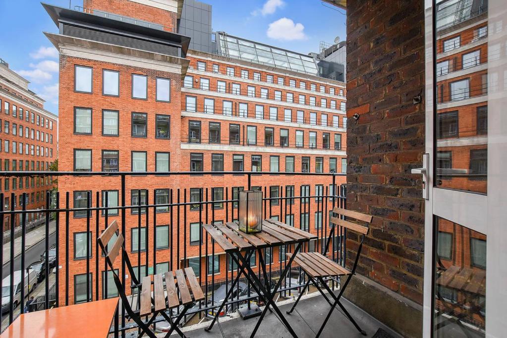 a balcony with a table and chairs and a building at Small One bedroom flat near Covent garden in London