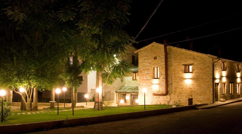 a building with lights on a street at night at Villa Martina in Fermignano