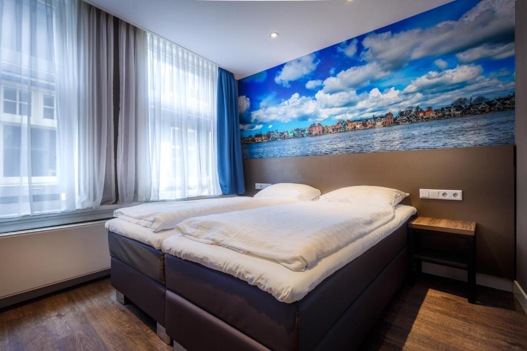 een slaapkamer met een bed met een schilderij aan de muur bij The Old Nickel Hotel in Amsterdam