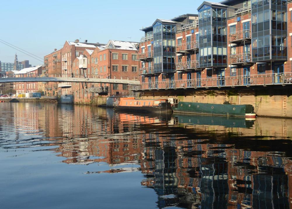 リーズにあるStylish Leeds City Centre Apartmentの川水面の建物の反射