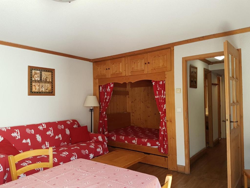 uma sala de estar com um sofá vermelho e um pequeno quarto em Studio d'Anaite em Les Houches