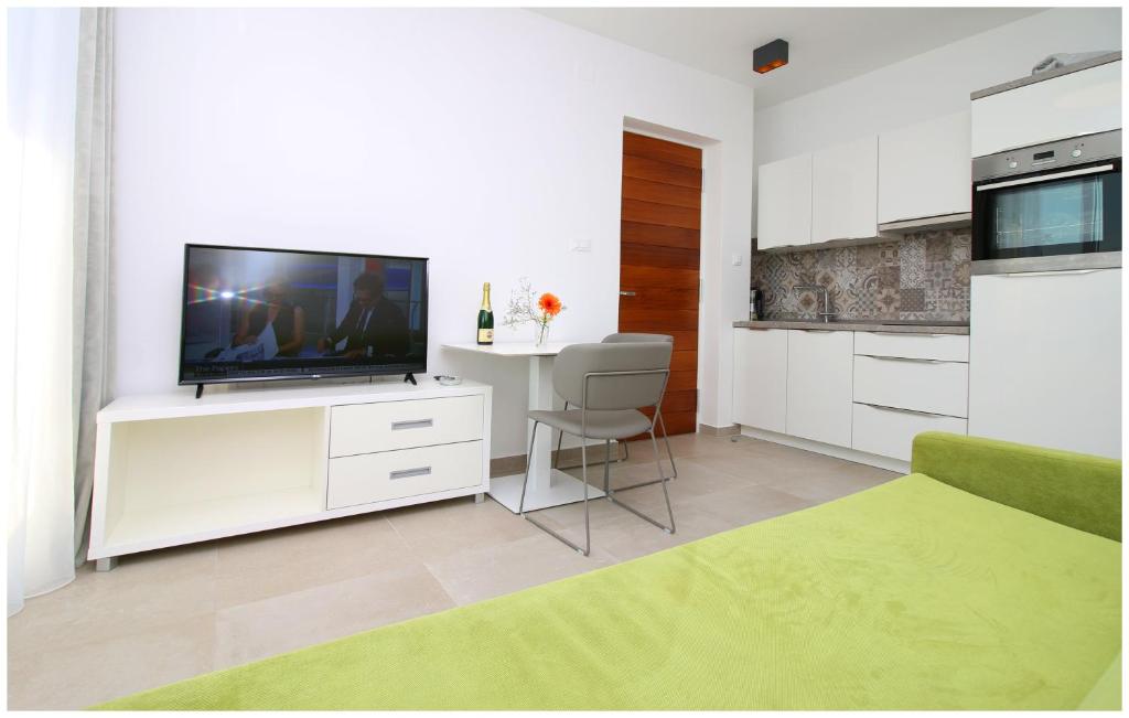 salon z telewizorem na białej szafce w obiekcie Apartments Ksenia w Rogoznicy