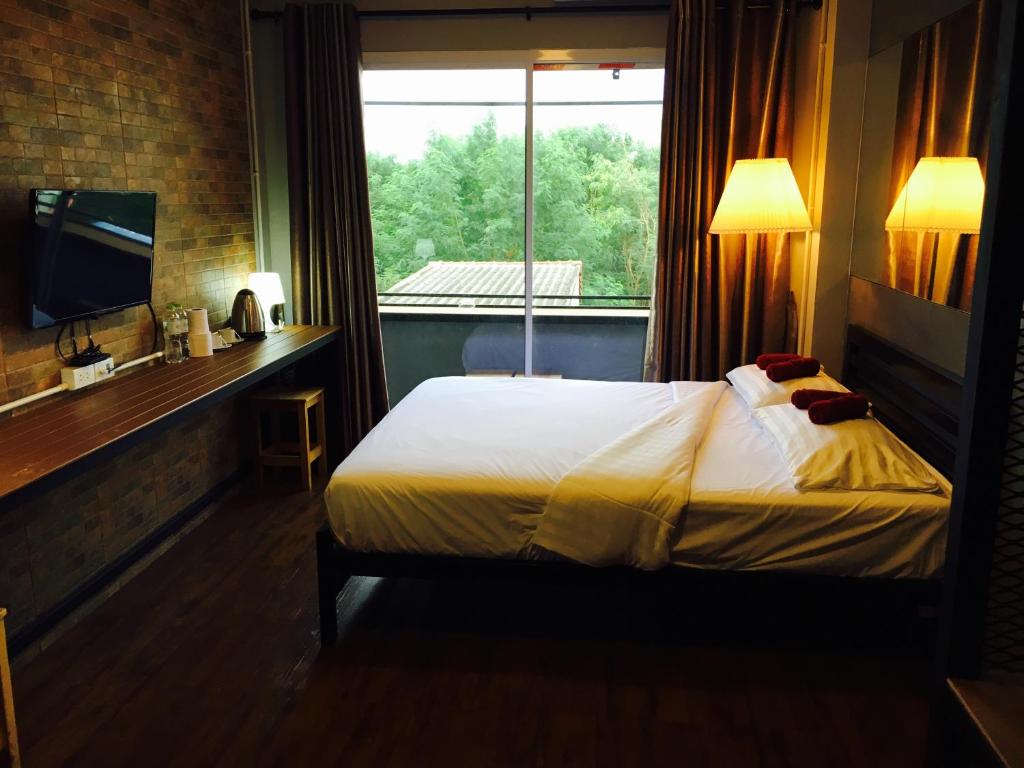 een hotelkamer met een bed en een raam bij Popcorn House Ratchada in Bangkok