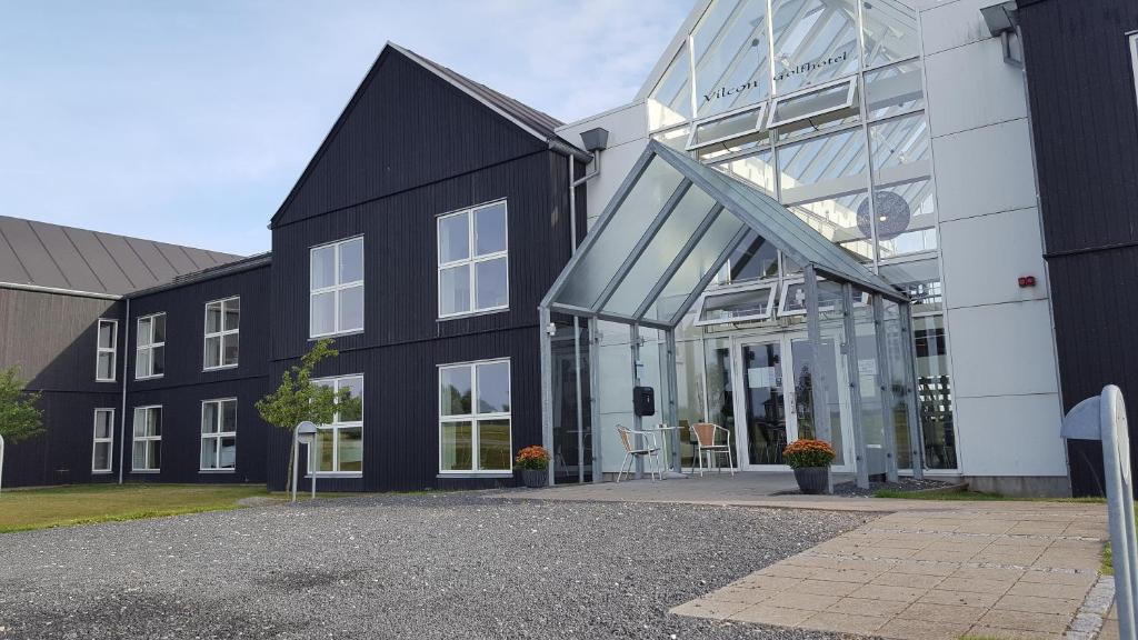 een zwart-wit gebouw met een glazen gevel bij OnlySleep Oksebrovej in Slagelse