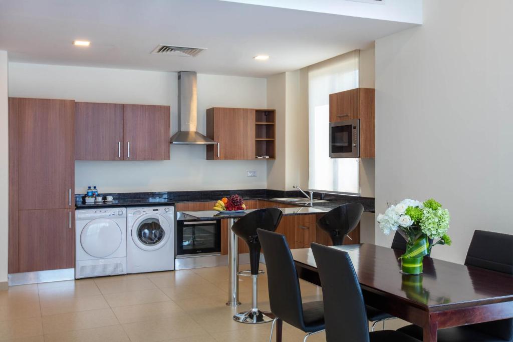 a kitchen with a table and a kitchen with a washing machine at Aspire Tower in Manama